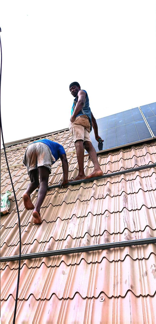 Technicians installing solar panels on a roof